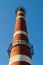 old aged weathered tall industrial factory chimney, red grungy brick smokestack grunge vintage