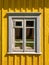 Old aged worn white window closeup exterior view wooden yellow house in the countryside