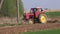 Old agriculture tractor cultivated field in spring