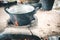 old aluminium pot on stove. water is boiling