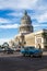Old American cars pass the Capitol Building