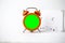 Old analog orange clock on a white background. The central part of the sart is green blank, left for inserting some content, and