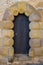 Old ancient black wooden door framed with big sandstone archway