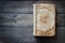 An old ancient book with empty cover on a wooden background.