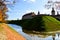 Old, ancient medieval castle with spiers and towers, walls of stone and brick surrounded by a protective moat with water