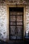 An old ancient wooden door in stones background in Corfu Greece. Antique castle entrance in rocks wall and frame made of wood. Bea
