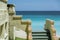 Old antique exterior vintage steps attached to the building wall against tranquil azure ocean and blue sky background