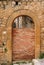 Old arched door blocked by brick wall