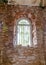 Old arched windows in an abandoned church, iron grilles in front of the windows, crumbling window sills and window sills