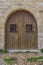 Old arched wooden door with barred windows