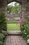 Old archway in old English country garden landcape in Spring wit