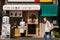 Old asian man walking on street while japanese women manager tries to invite customer to have breakfast or lunch meal at local jap