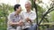 Old Asian senior couple morning date with cup of coffee in green