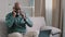 Old bald African business man with gray beard aged male employer sitting on sofa working with laptop feels sudden