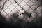 Old barbed wire is tangled on a chain-link fence that stands against a dark, overcast sky. Prison sentence. Restriction of freedom