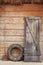 Old barn door, dirty old tire and shovel leaning against the wooden barn door
