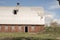 Old barn on a farm, blue sky in background.