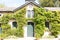 An old barn with front is covered with beautiful colored ivy during autumn. Fernleigh farm phoenix park dublin stables