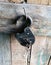 An old barn lock with keys, in a wooden shed, hanging from a large nail.