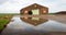 Old barn reflected in a puddle of water