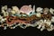 Old beads of turquoise, red coral, amber, garnet stone, multi-colored agate, pearls among various shells on black background