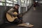 Old beggar play guitar to beg money