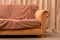 Old beige sofa. Crumpled blanket on the couch. Modern style. Cushioned furniture. Furniture for rest