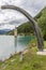 The old bell tower of Curon Graun emerging from the waters of Lake Resia, South Tyrol, Italy, vertically framed by a wooden arch