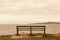 Old bench facing an open view with sea and mountains.