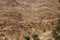 Old berber village oasis with houses build of clay bricks in front of impressive high rugged red mountain face