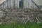 An old bicycle leaning against the stone wall of a weathered farm building