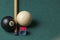 Old billiard ball 8 and stick on a green table. billiard balls isolated on a green background.Black and white