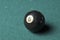 Old billiard ball number 8 black color on green billiard table, copy space