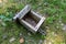 Old bird feeder lying on the forest litter. Wooden birdhouse