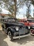 old black 1940 Chevrolet Chevy Master sport sedan by GM in a park. AAA 2022 classic car show