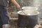 An old black aluminum pot boiling on natural fireplace