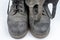 Old black dirty shoes. Leather military footwear on a white table.