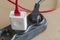 Old black extension cord on the floor with connected consumers