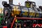 Old black and red retro steam locomotive at the railway station with a view onto a pipes inside