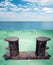 Old black rusted stern bollard mounted on green ship deck