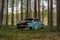 Old blue car wreck standing in a forest in Sweden