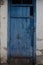 Old blue door. cracked paint. old white wall