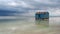 Old blue house abandoned in the middle of the salt lake during an approaching storm. Salar Baskunchak