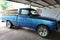 An old blue Mazda Family pickup parked in the garage.