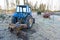 Old blue tractor standing ready to plow snow