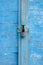 Old blue wooden plank gate with a padlock