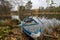 Old boat in october with lots of leafs