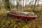 Old boat in october with lots of leafs