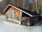 Old boathouse by frozen lake