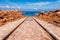 Old boats launching rail with red rocks against blue sky in Brittany, France